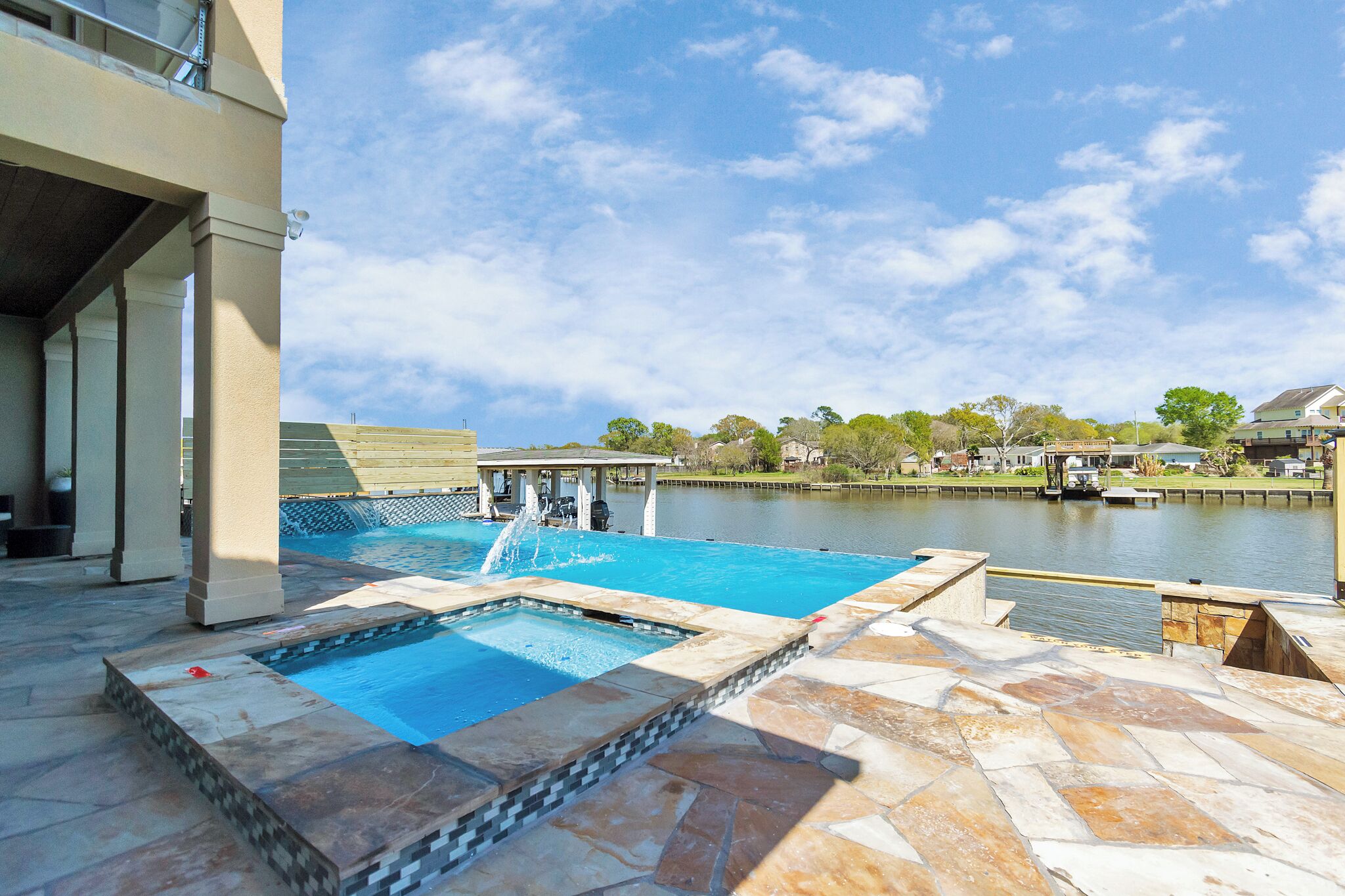 A swimming pool with a view of a body of water and a building in the background.