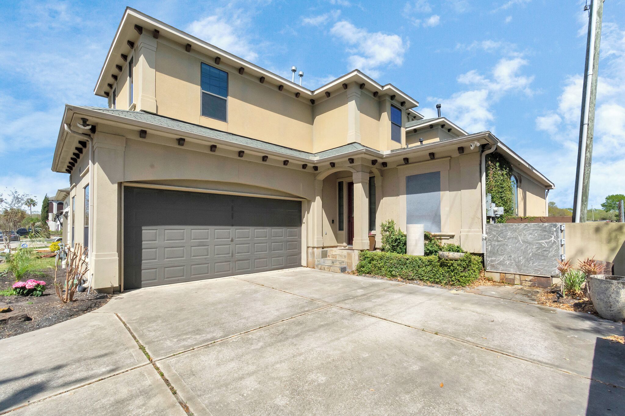 A two-story house with a garage, a driveway, and a landscaped front yard.