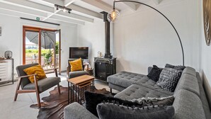 A modern living room with a sofa, armchair, and a fireplace.