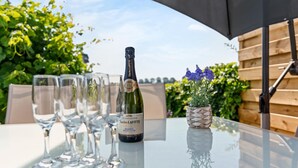 A table with a bottle of champagne, glasses, and a potted plant.