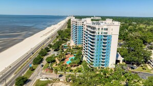 A high-rise hotel with multiple balconies, a swimming pool, and a beach view. - Legacy Tower II- #1406 - 2BR/2BA Penthouse Gulf-View Condo - Resort Pools + Spa (Gulfport)