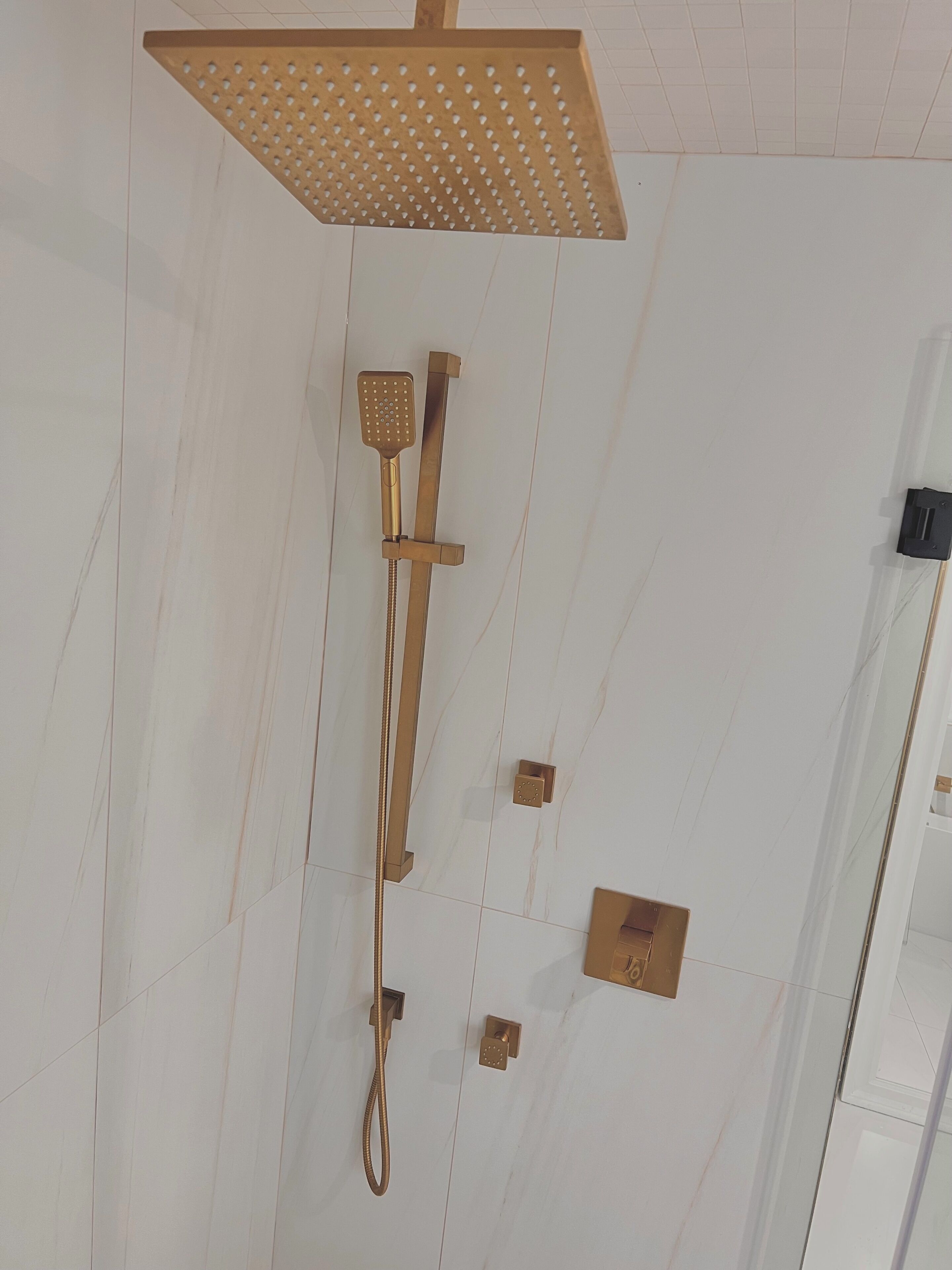 A showerhead with a square design and a handheld shower attachment.