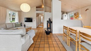 Ein modernes Interieur mit einer Couch, einem Esstisch und einem Fernseher.