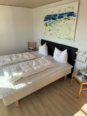 A double bed with white bedding, a black headboard, and a wooden floor. - Lovely holiday home with beautiful views (Sydals)