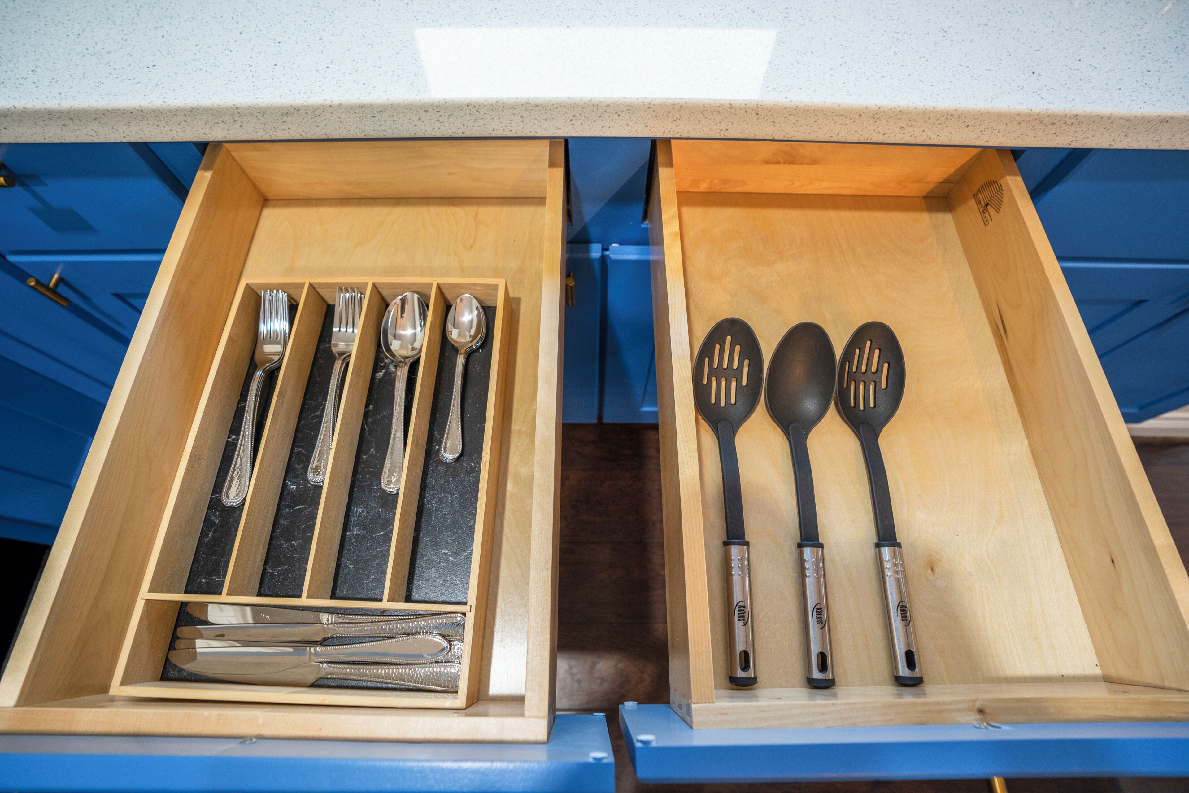 A drawer with utensils, including forks, spoons, and spatulas.