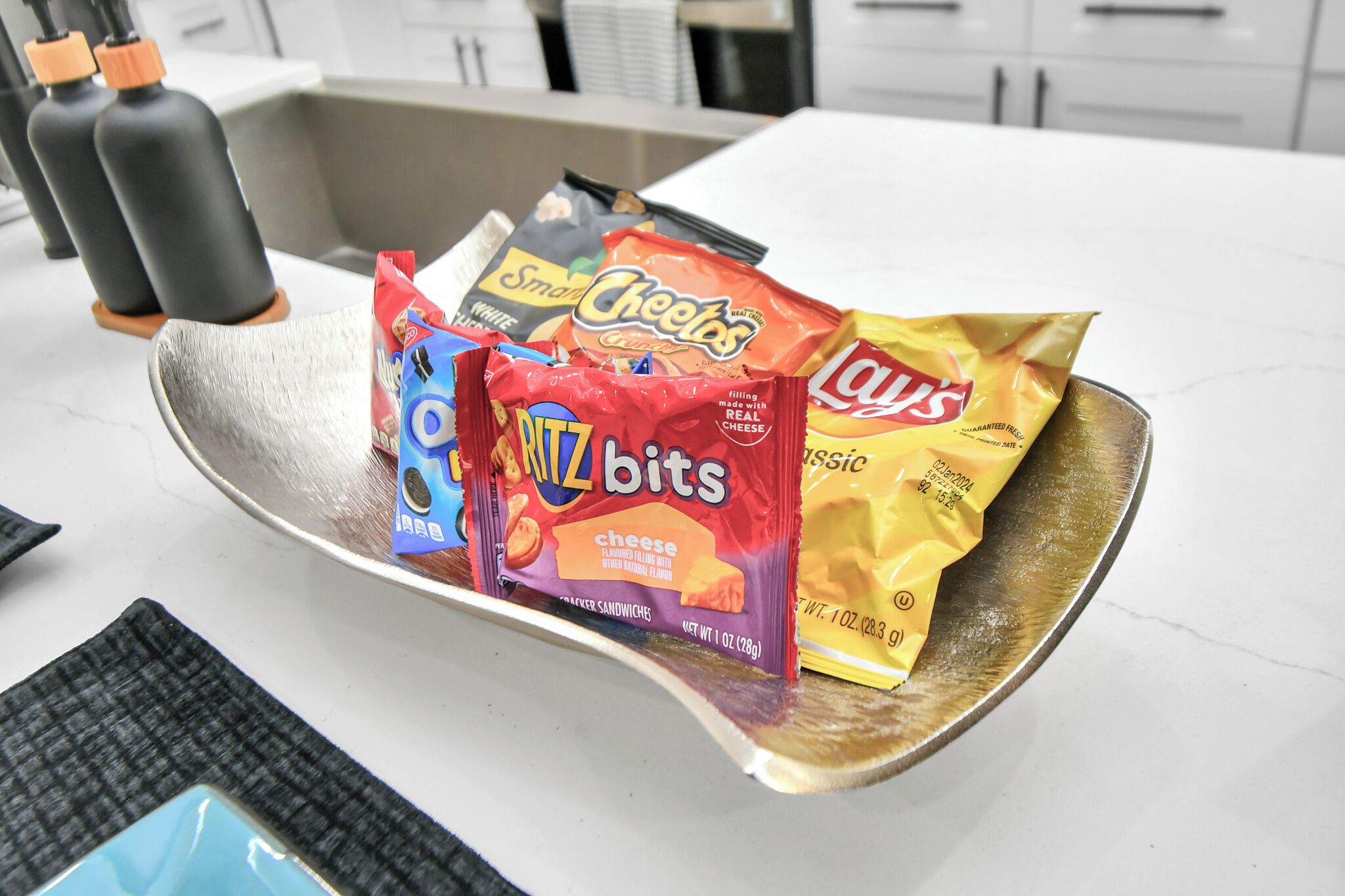 A kitchen counter with various snack bags.