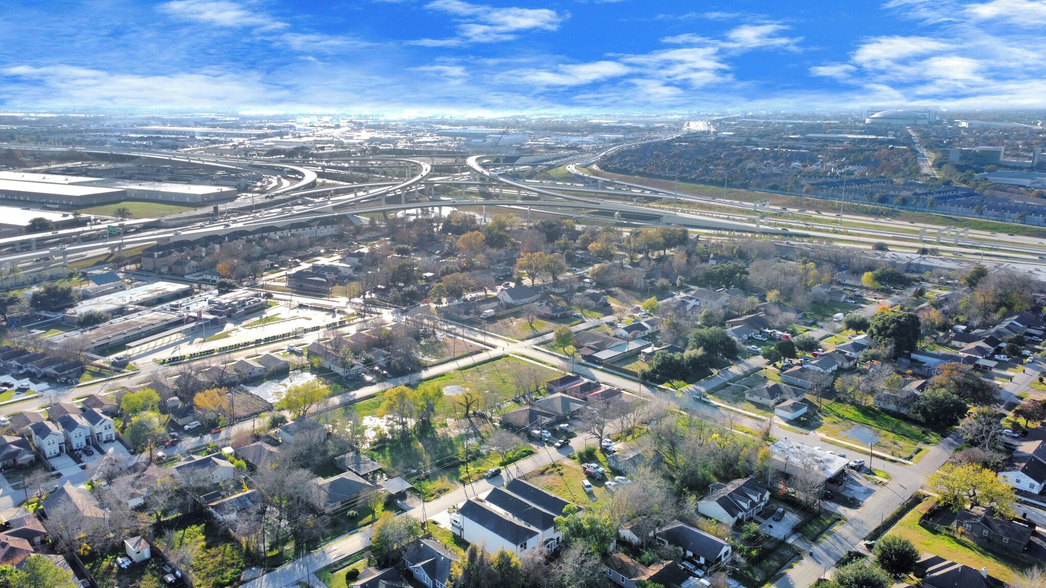 Luchtbeeld van een woongebied met huizen, wegen en een snelwegknooppunt.