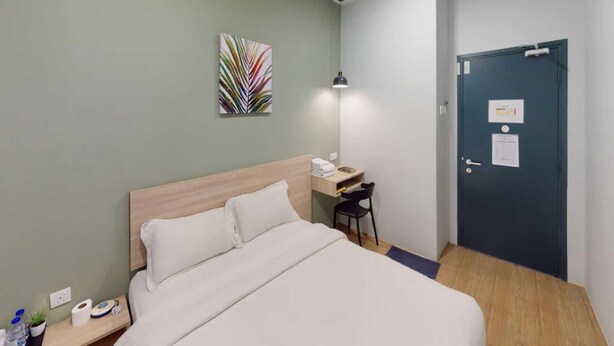 A hotel room with a bed, a desk, a chair, a door, and a wall-mounted artwork. - HOTEL O OYA INN @ KLIA (Sepang)
