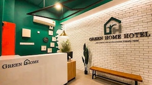 A reception desk with a sign reading 'GREEN HOME HOTEL' and a brick wall with a similar sign. - HOTEL O OYA INN @ KLIA (Sepang)