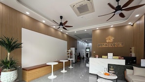 A hotel reception area with a reception desk, seating area, and ceiling fans. - Mimocha Hotel - Hoa Lu Ancient Town Ninh Binh (Hoa Lu)