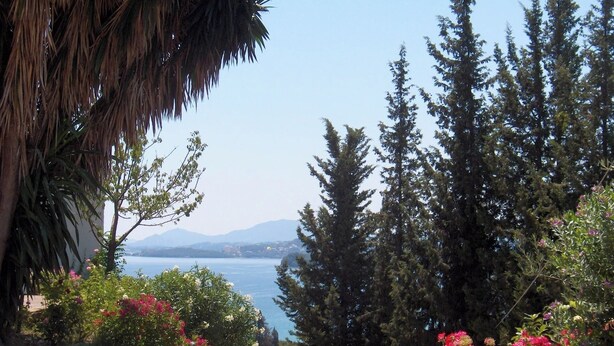 A coastal view with a clear sky, a body of water, and dense greenery. - Marilena Sea View (Pirgi)