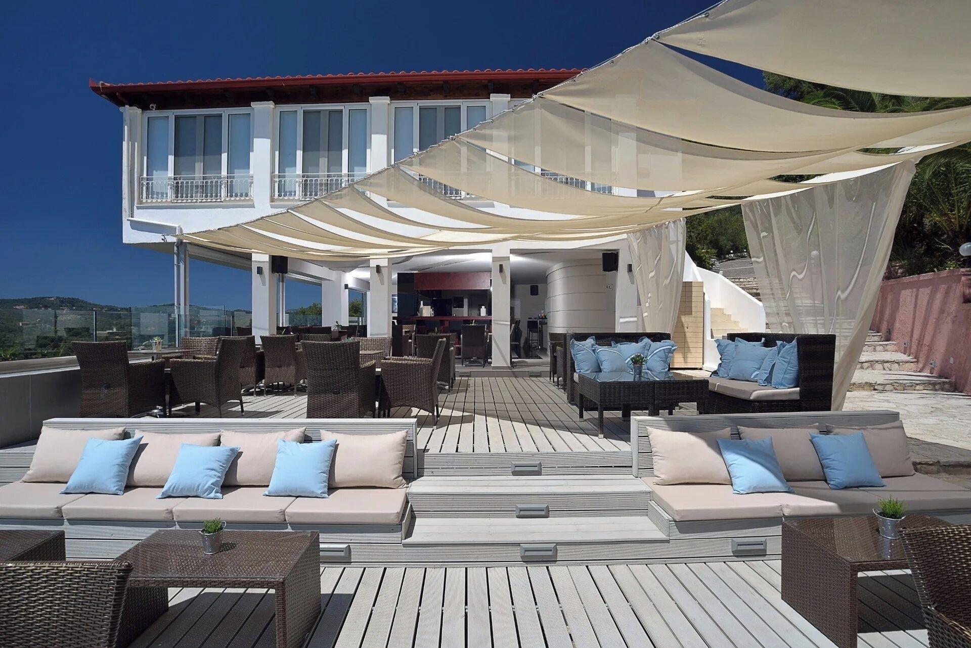 Une terrasse sur le toit avec des sièges extérieurs, un espace de restauration couvert et une vue sur le paysage.