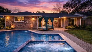 A residential property with a swimming pool, a covered outdoor seating area, and a brick exterior. - Empress Solace Villa (Friendswood)