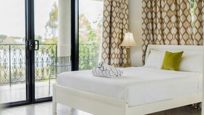 A hotel room with a bed, a window, and a view of the outdoors.