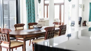 Uma sala de jantar com uma mesa comprida, cadeiras e uma tigela decorativa.