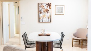 Un coin repas avec une table ronde, deux chaises et une seule tasse posée sur la table.