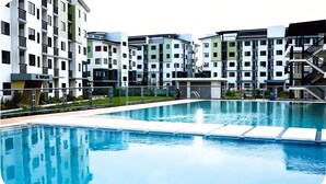 Una piscina con un complesso residenziale moderno sullo sfondo.