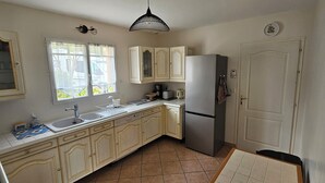 A kitchen with a refrigerator, double sink, and cabinets. - SEPTEMBER SPECIAL: Vacation Rental in St Gilles Croix de Vie (Le Fenouiller)