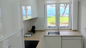 Una cocina compacta con lavavajillas, lavadora, cocina y fregadero.