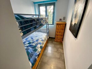 A bunk bed room with a window, wooden dresser, and a painting on the wall. - Le Corbier lodge 43 2-bedroom apartment at the foot of the slopes (Villarembert)