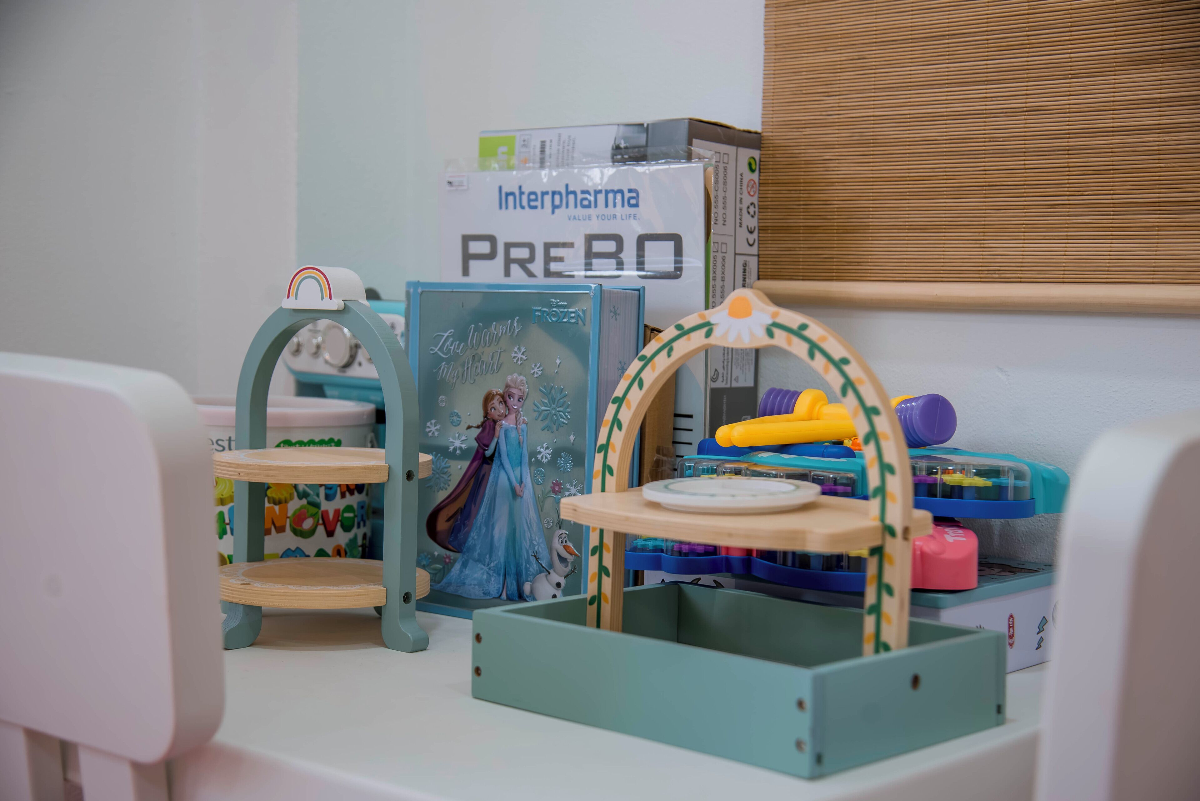 Zona de juegos infantiles con juguetes de temática invernal, una cocina de juguete y un comedor de juguete.