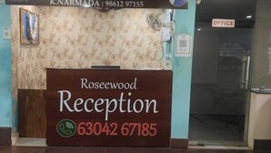 A reception desk with a sign for Rosewood Reception and a phone number. - Rosee Wood (Visakhapatnam)