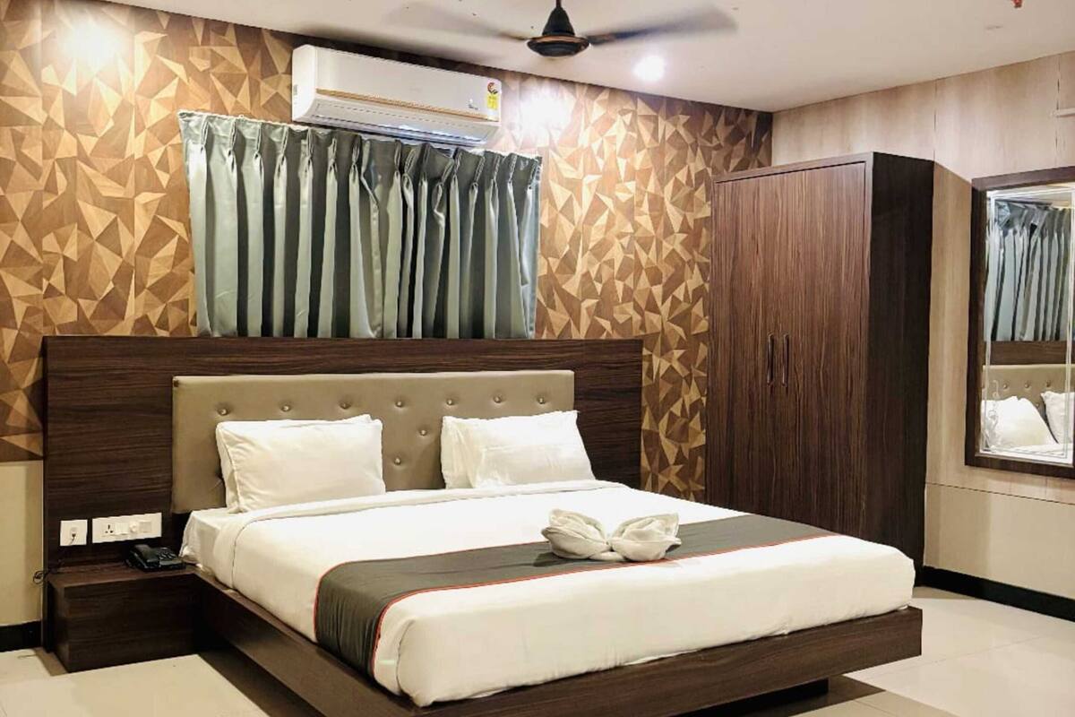 Un dormitorio moderno con una cama grande, ventilador de techo, aire acondicionado y armario.