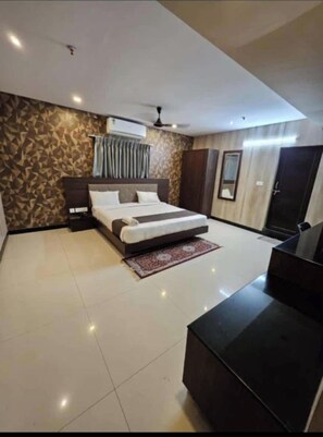 Quarto moderno com cama, mesas de cabeceira, escrivaninha e guarda-roupa.
