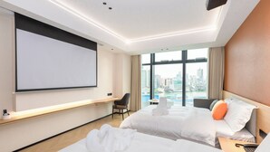 A hotel room with two beds, a desk, a chair, a TV, and a city view. - Zhuhai Yueao Cross-Border Hotel - Zhuhai Branch (Zhuhai)