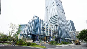 A modern high-rise building with reflective glass windows, a prominent entrance, and a well-maintained surrounding area with greenery and a clear road. - Zhuhai Yueao Cross-Border Hotel - Zhuhai Branch (Zhuhai)