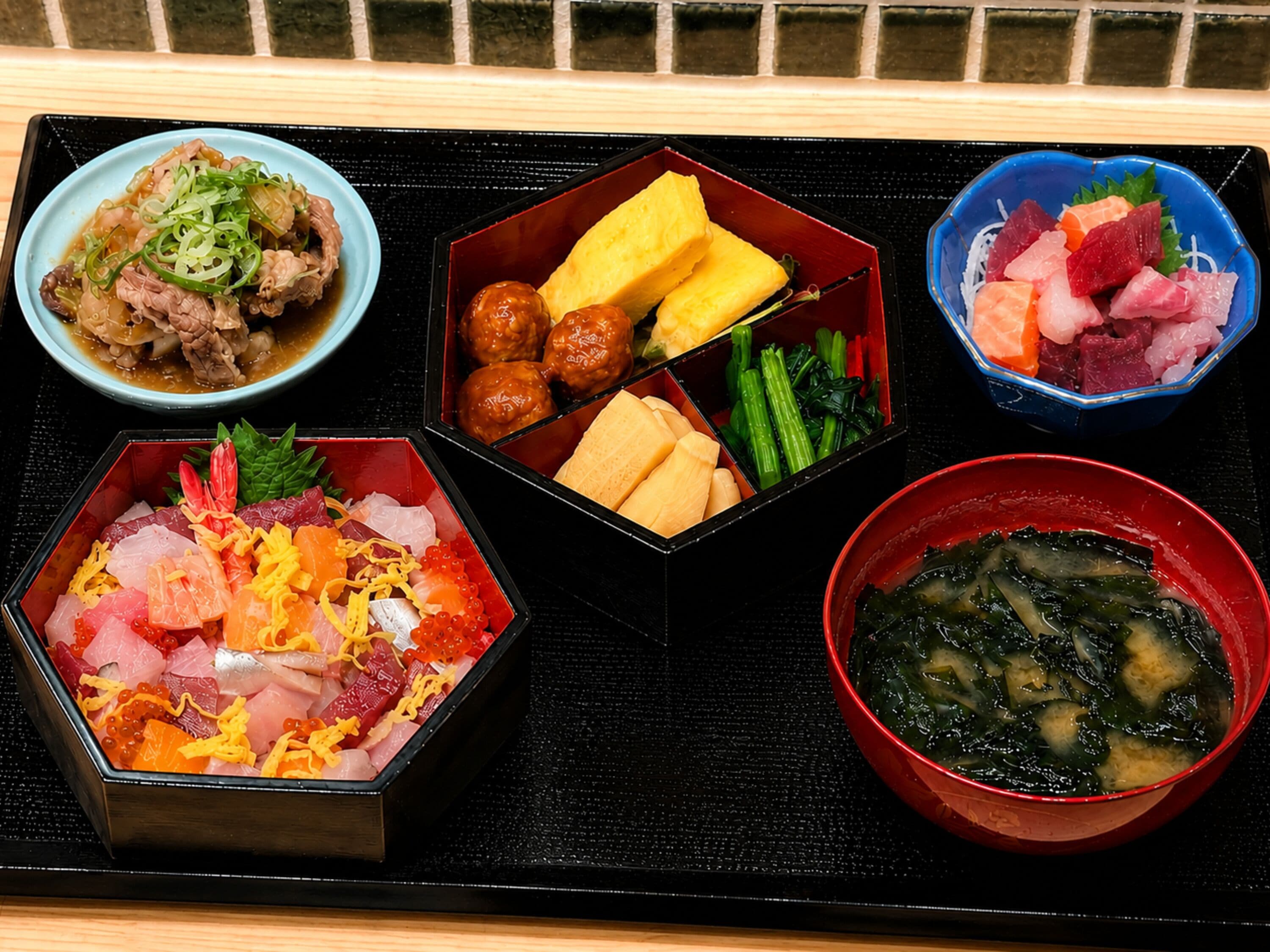 A tray with various food items including sashimi, vegetables, and a bowl of soup.