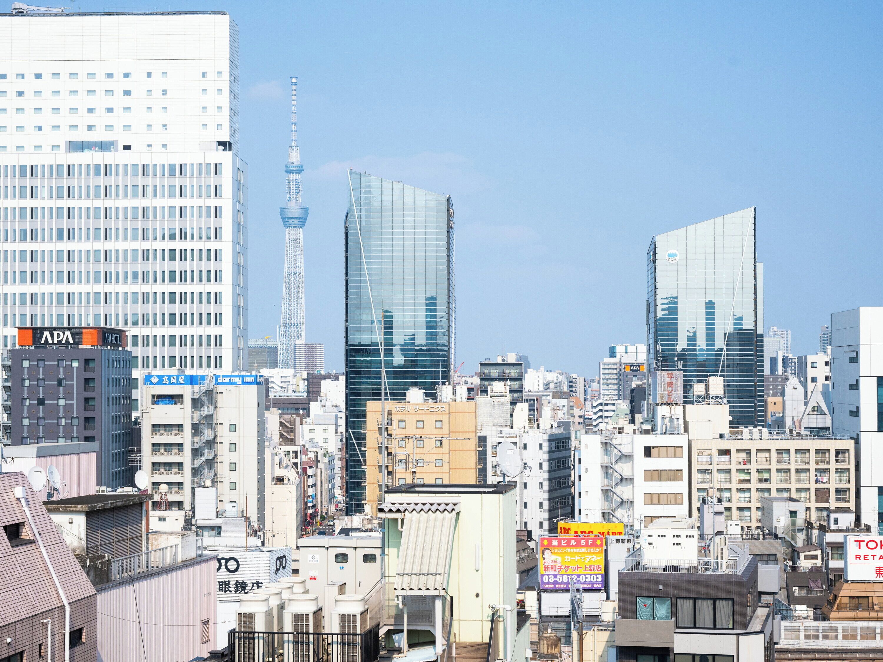 A cityscape with modern buildings, including a prominent tower and several high-rise structures.
