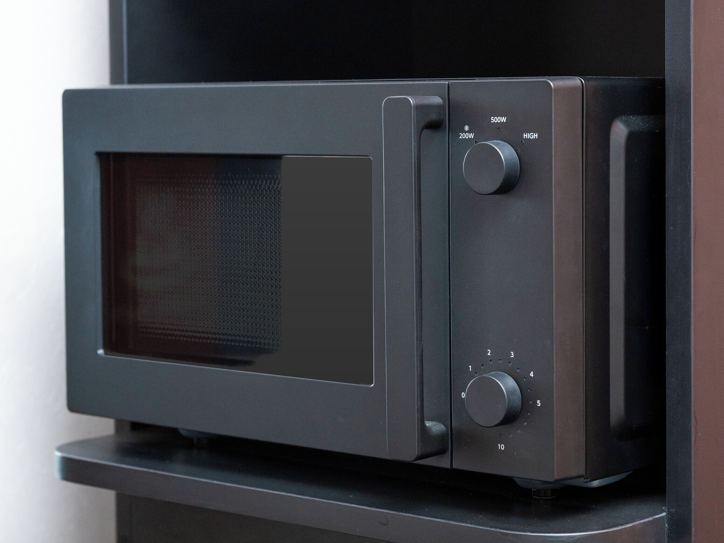 A microwave oven with a digital display and control knobs.
