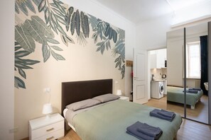 Une chambre à coucher avec un lit, une table de chevet et un grand miroir.