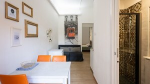 Una habitación de hotel compacta con comedor, cama y ducha.