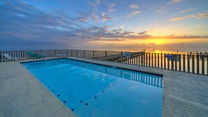Une piscine rectangulaire avec une terrasse en bois et une clôture blanche.