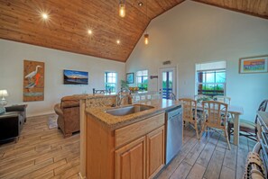A spacious kitchen with wooden cabinets, a granite countertop, and a built-in dishwasher. - 3 Laguna Madre Homes • Pool + Bay Access | Sleeps 21 | Laguna Village Collection (Corpus Christi)