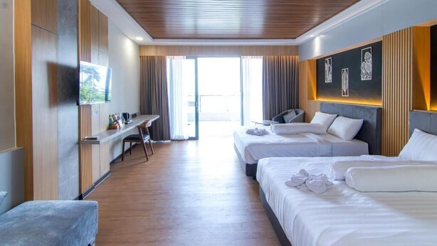 A hotel room with two beds, a desk, a TV, and a view of the outdoors. - Azana BeSt Hotel Batu (Batu)
