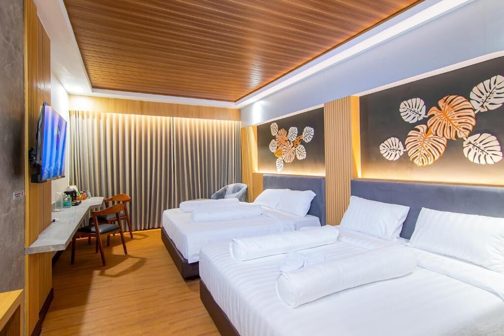 Een hotelkamer met twee bedden, een bureau en een televisie.