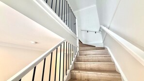 Eine Treppe mit Holzbalken und weißen Geländern.