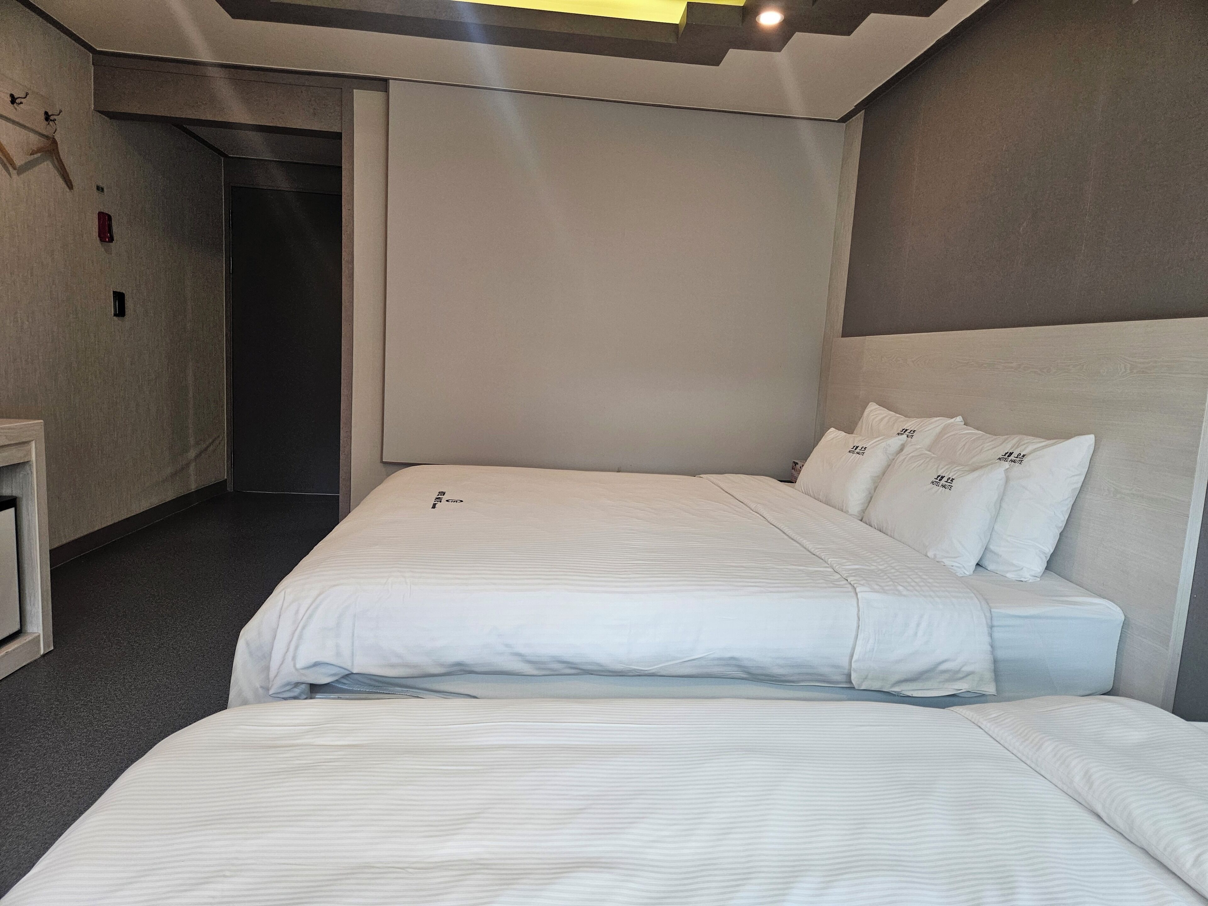 Ein Hotelzimmer mit einem großen Bett, einem Nachttisch und einer Tür zu einem anderen Raum.