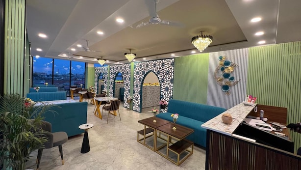A modern interior with seating, a bar area, and a view through large windows. - Hotel Highway Retreat (Dhanaura)