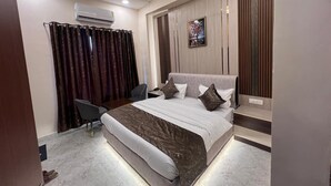 A modern bedroom with a bed, a desk, and a chair. - Hotel Highway Retreat (Dhanaura)