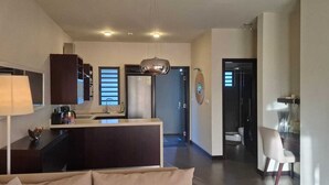 A modern kitchen with dark cabinetry, a central island, and a pendant light.