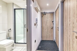 Ein Badezimmer mit Toilette, Dusche und einer Duschkabine.