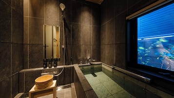 A modern bathroom with a large bathtub, a shower, and a vanity with a mirror.
