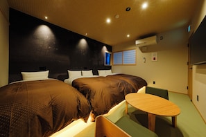 Een hotelkamer met twee bedden, een tafeltje en een raam met uitzicht.