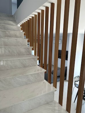 Una escalera de mármol con soportes verticales de madera.