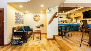 A living room with a sofa, coffee table, and a clock on the wall. - Dual-view luxury corner retreat, artisan touches (Bangkok)