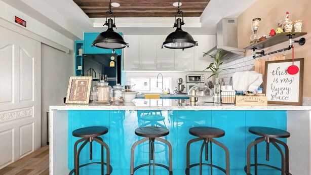 A kitchen with a central island, bar stools, pendant lights, and a shelf with decorative items. - Take Time Out on the Serene Balcony in the City (Bangkok)
